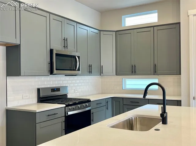 a kitchen with stainless steel appliances and white cabinets