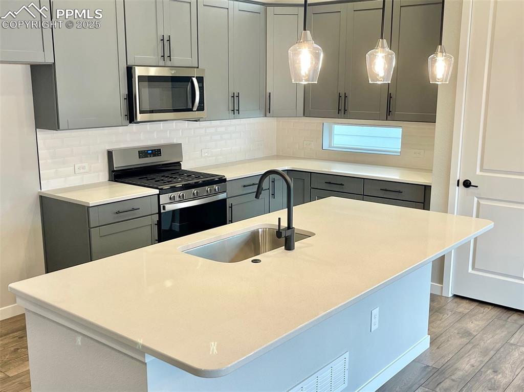 6593 Vistancia Avenue Colorado Springs, CO 80922 - Photo 3 of 21 a kitchen with stainless steel appliances a sink a stove top oven a counter space and cabinets