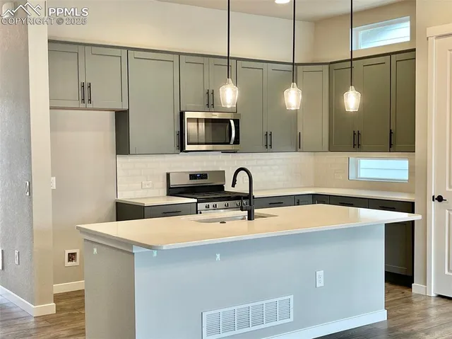 a kitchen with a sink a microwave and refrigerator