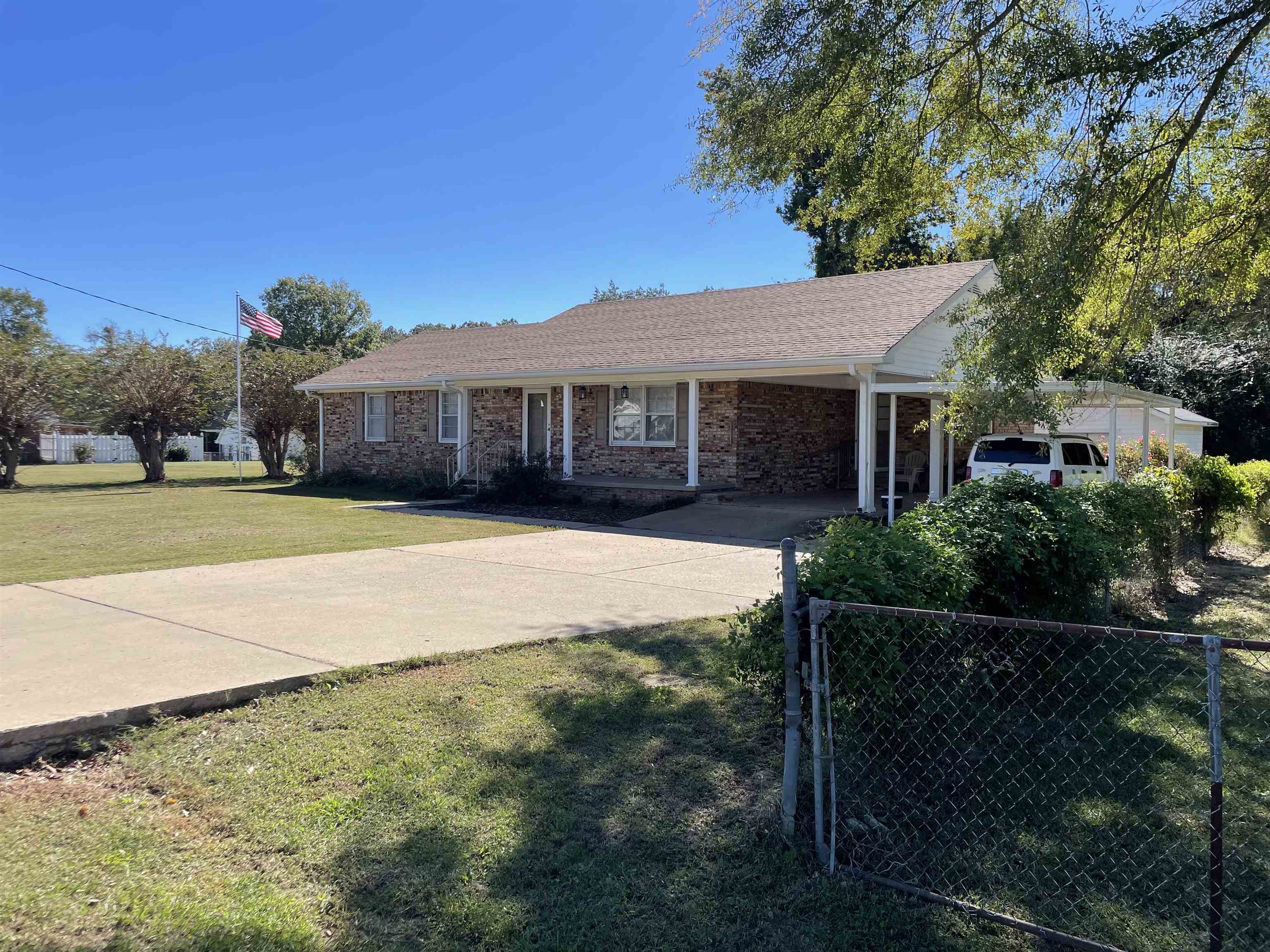a view of a house with backyard and trees
