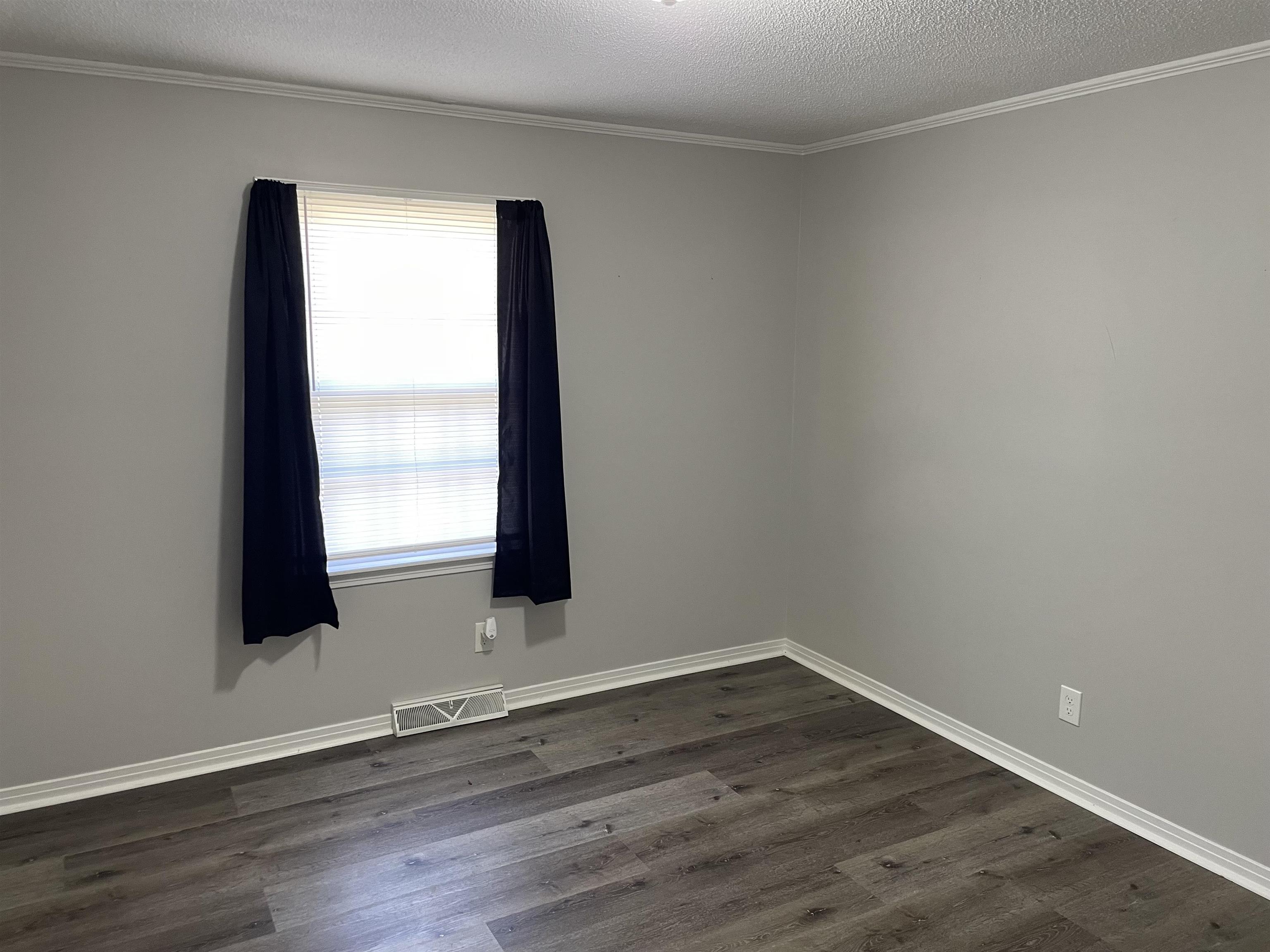 235 Paine Road Savannah, TN 38372 - Photo 13 of 28 an empty room with wooden floor and windows