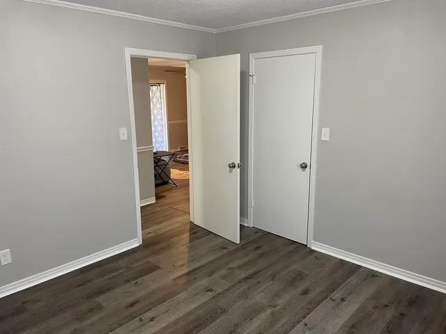 an empty room with wooden floor & closet