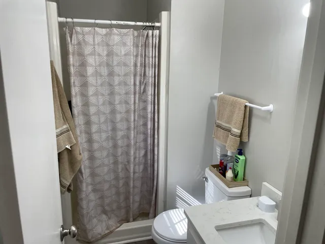a bathroom with a shower curtain and a toilet