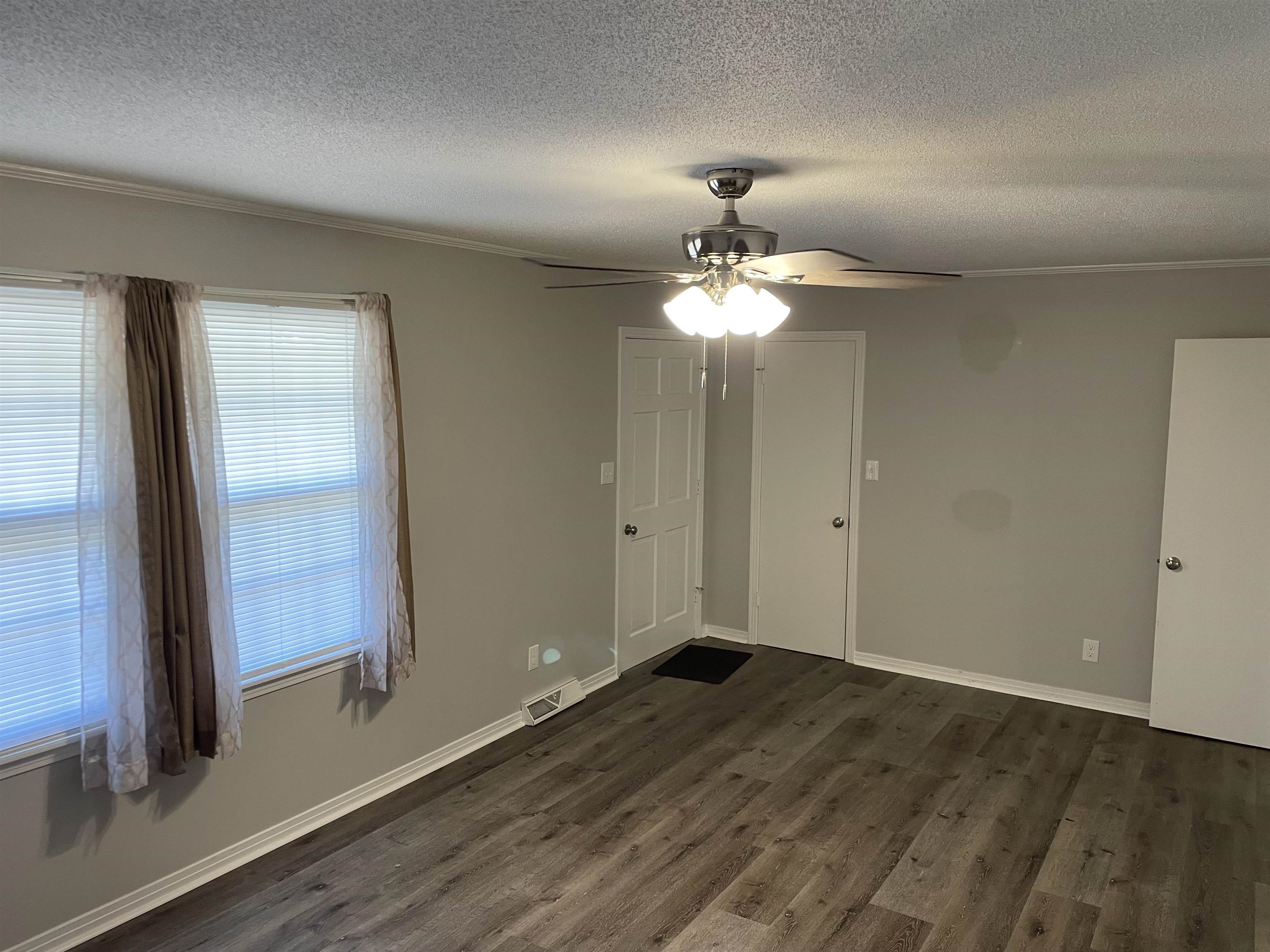 235 Paine Road Savannah, TN 38372 - Photo 10 of 28 an empty room with wooden floor and chandelier