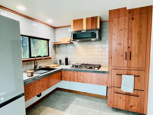 a kitchen with stainless steel appliances granite countertop a stove a sink and a refrigerator