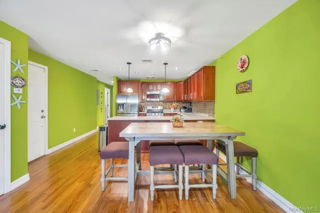 a kitchen with stainless steel appliances kitchen island granite countertop a refrigerator a stove top oven a sink and dishwasher