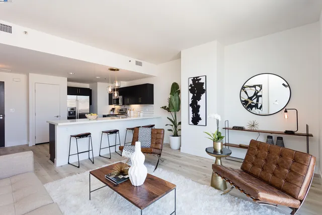 a living room with furniture kitchen view and a mirror