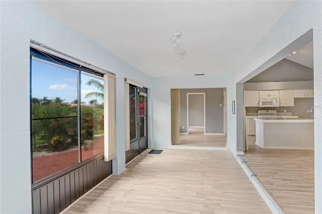 a view of a hallway with wooden floor and a living room