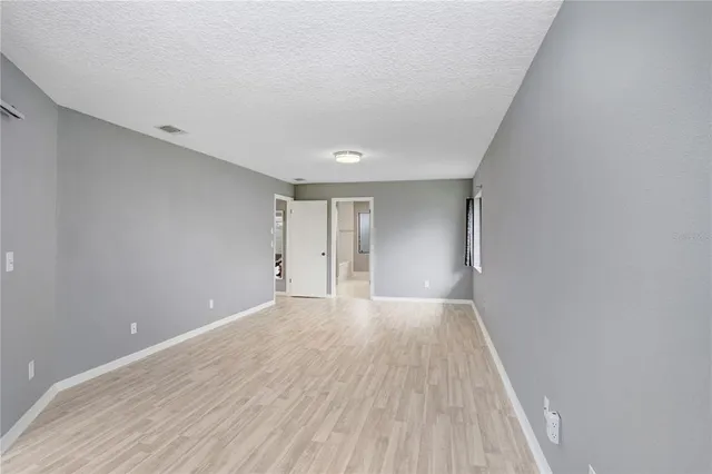 a view of an empty room with wooden floor