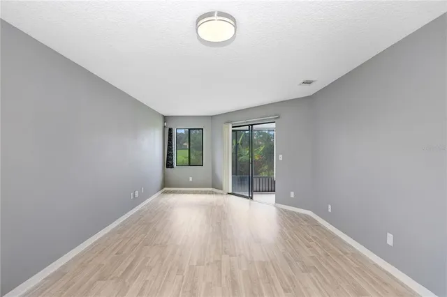 a view of hallway with window and wooden floor