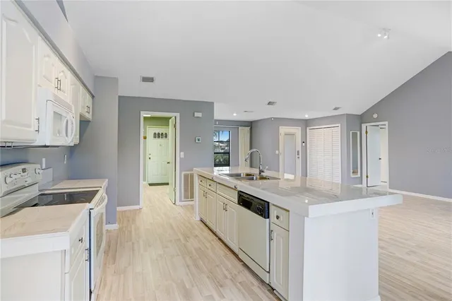 a kitchen with white cabinets sink and stove