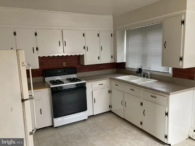 a kitchen with granite countertop white cabinets and black appliances