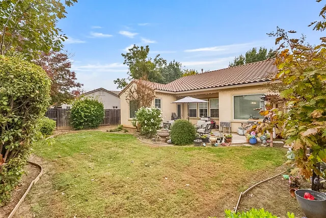 a view of a house with backyard and sitting area