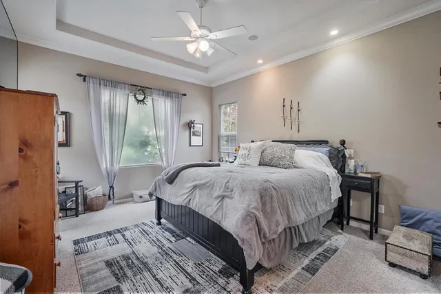 a spacious bedroom with a bed a couch and a large window