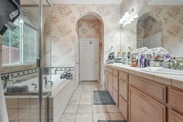 a bathroom with a double vanity sink a toilet a shower and a mirror