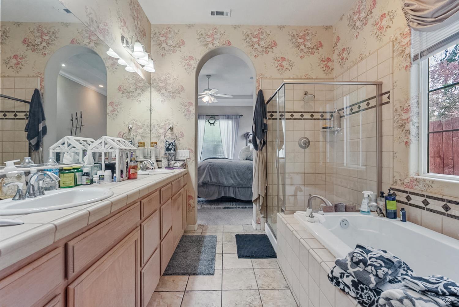 191 Fall Avenue Patterson, CA 95363 - Photo 6 of 31 a bathroom with a double vanity sink a large mirror and bathtub
