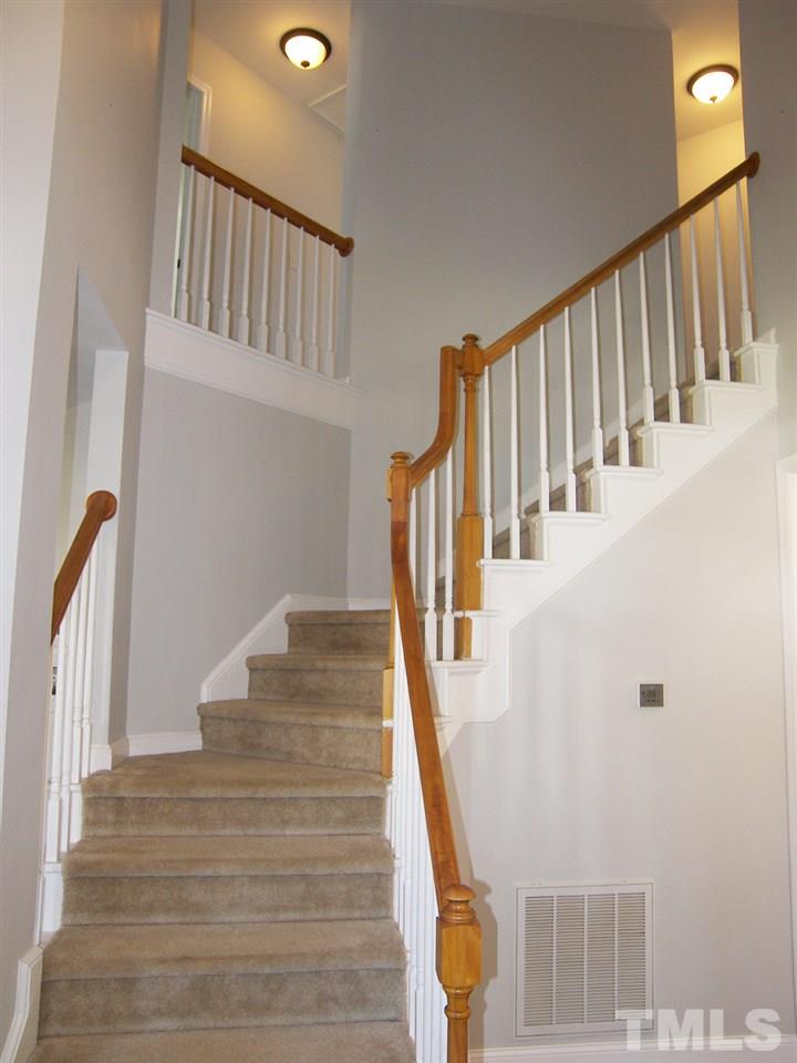 11933 Fairlie Place Raleigh, NC 27613 - Photo 11 of 25 a view of staircase with lots of frames on wall and wooden floor