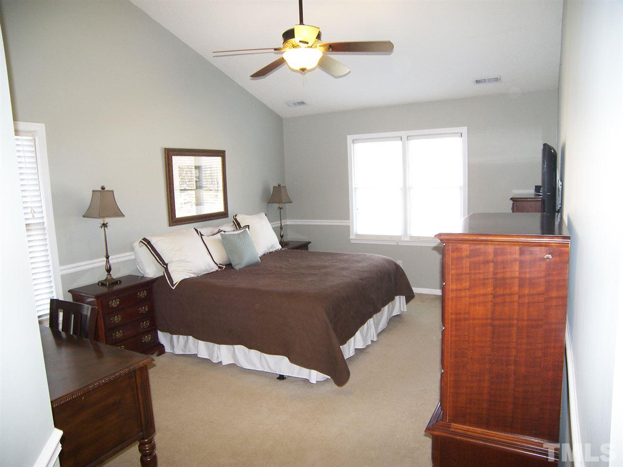11933 Fairlie Place Raleigh, NC 27613 - Photo 12 of 25 a bedroom with a bed and a chandelier