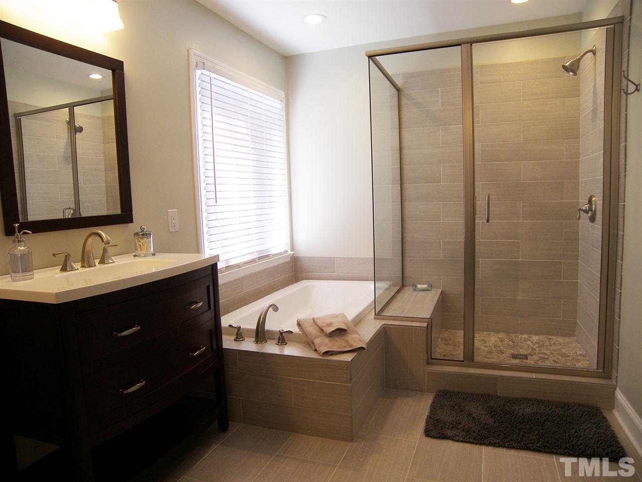 11933 Fairlie Place Raleigh, NC 27613 - Photo 13 of 25 a bathroom with a tub sink shower and mirror