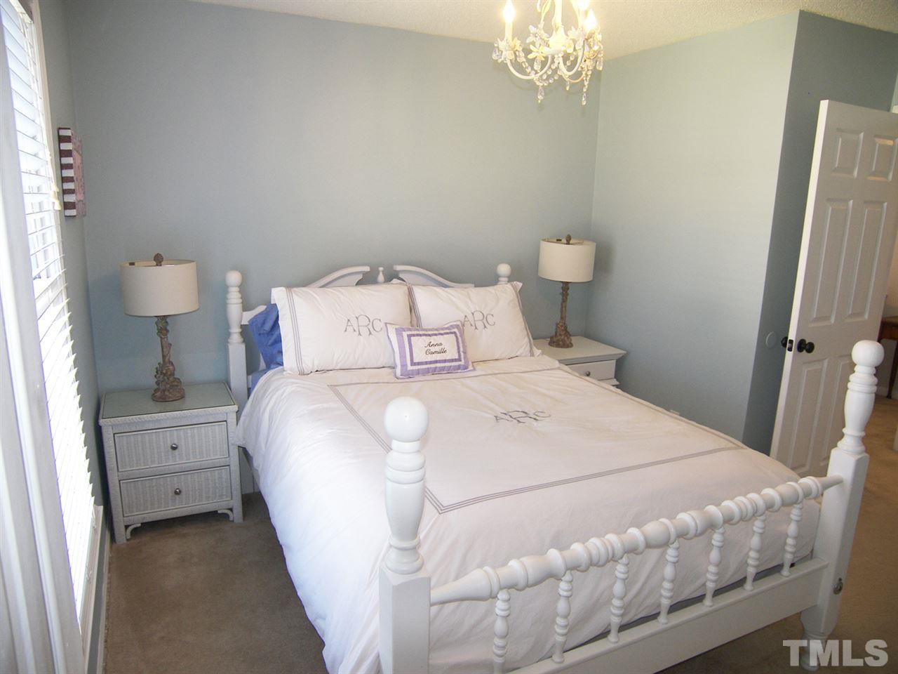 11933 Fairlie Place Raleigh, NC 27613 - Photo 17 of 25 a large white bed in a small room