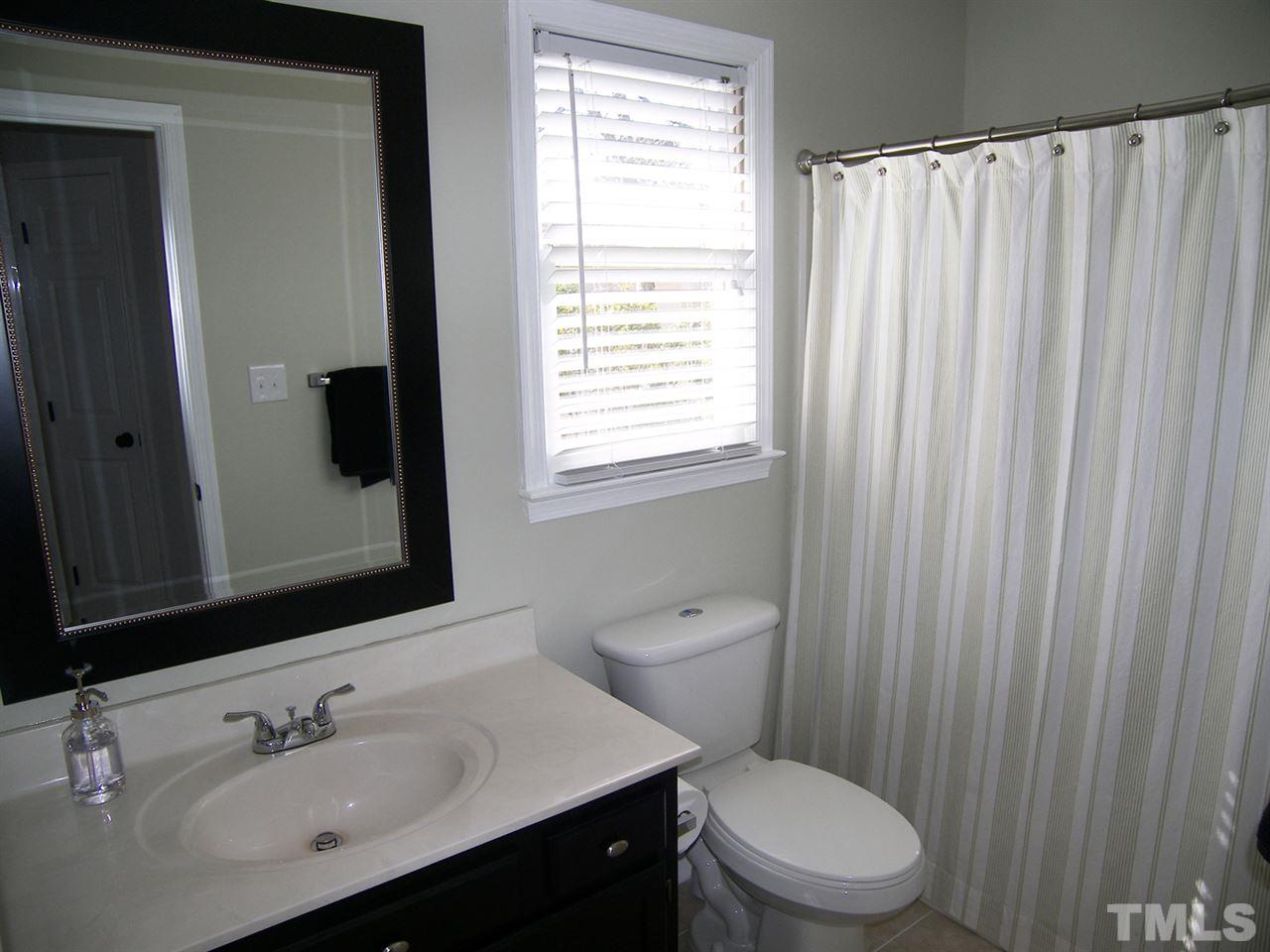 11933 Fairlie Place Raleigh, NC 27613 - Photo 20 of 25 a bathroom with a sink a toilet and a mirror