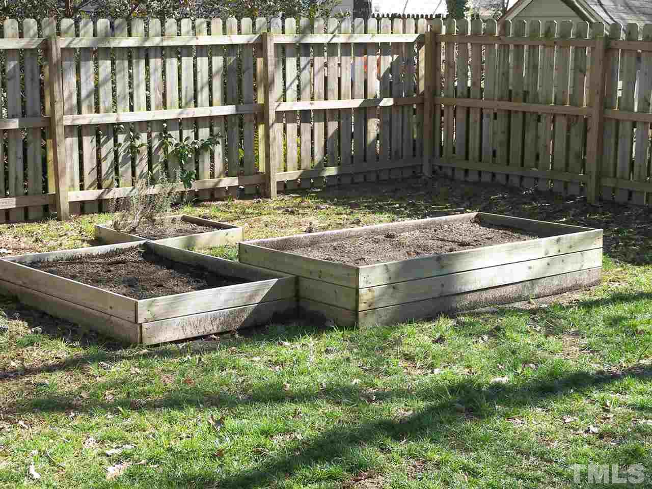 11933 Fairlie Place Raleigh, NC 27613 - Photo 22 of 25 a view of a backyard with couches plants and wooden fence