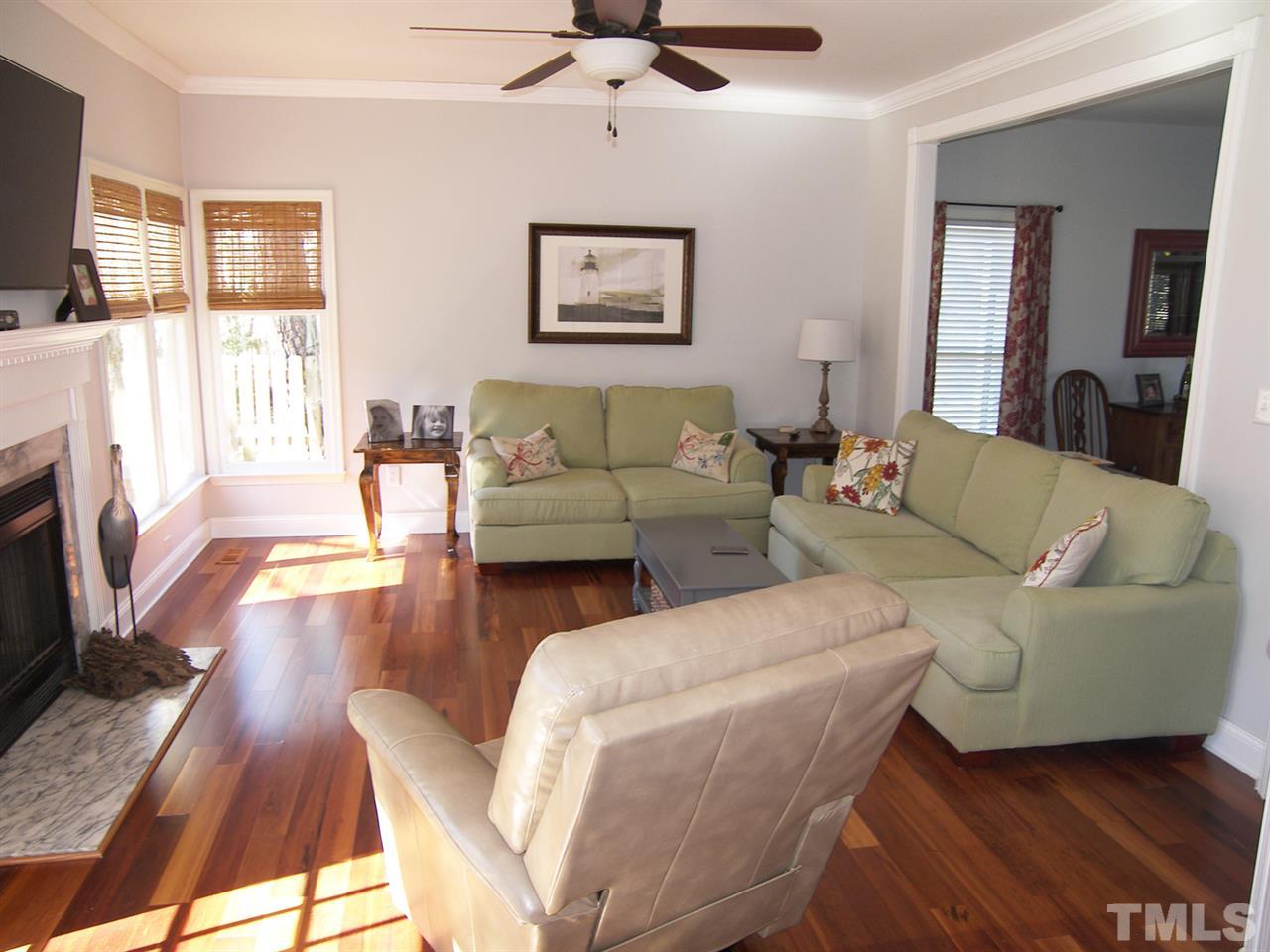11933 Fairlie Place Raleigh, NC 27613 - Photo 6 of 25 a living room with fireplace furniture and a flat screen tv