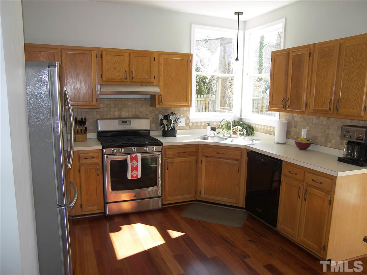 11933 Fairlie Place Raleigh, NC 27613 - Photo 8 of 25 a kitchen with a sink stove and cabinets