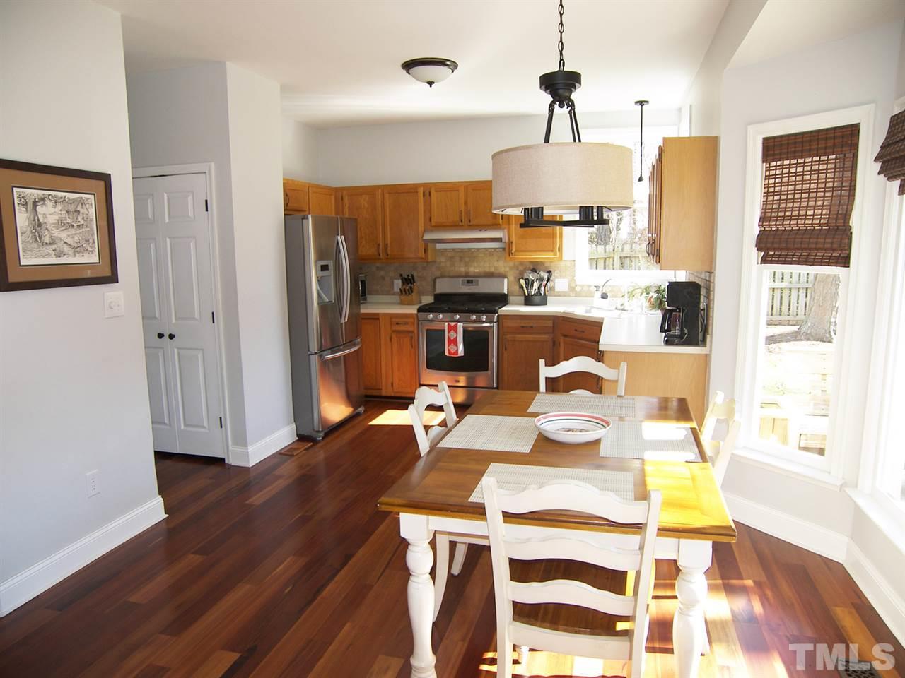 11933 Fairlie Place Raleigh, NC 27613 - Photo 9 of 25 a view of a dining room with furniture wooden floor and chandelier