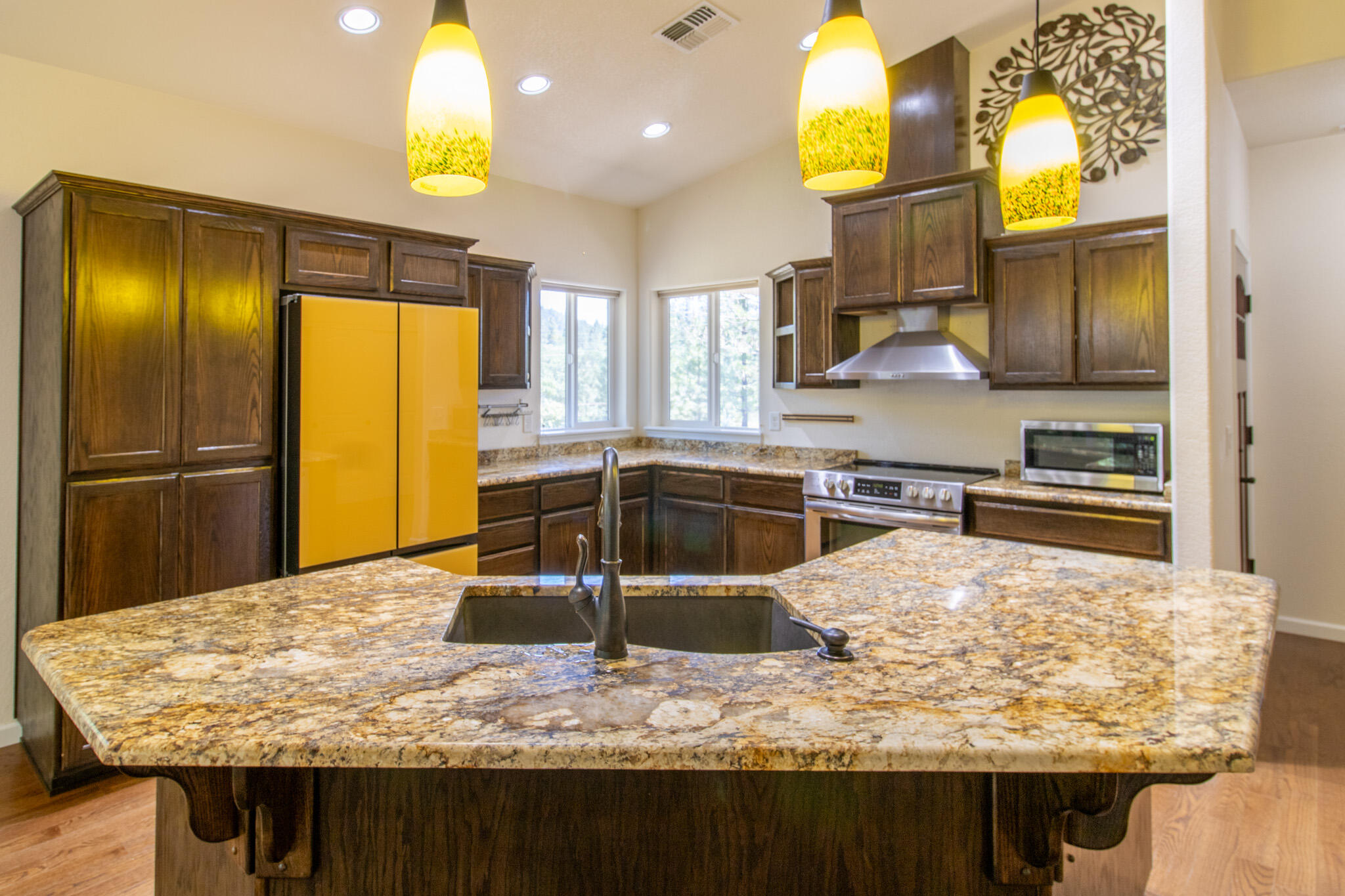 337 Cedar Ridge Drive Cave Junction, OR 97523 - Photo 13 of 56 a kitchen with kitchen island granite countertop wooden cabinets and a counter top space