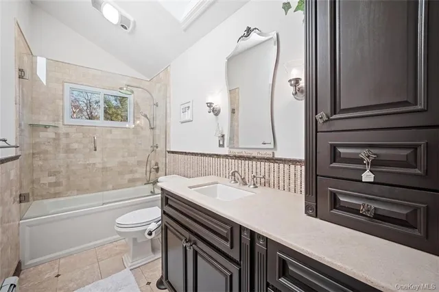 a bathroom with a sink a toilet a mirror and shower