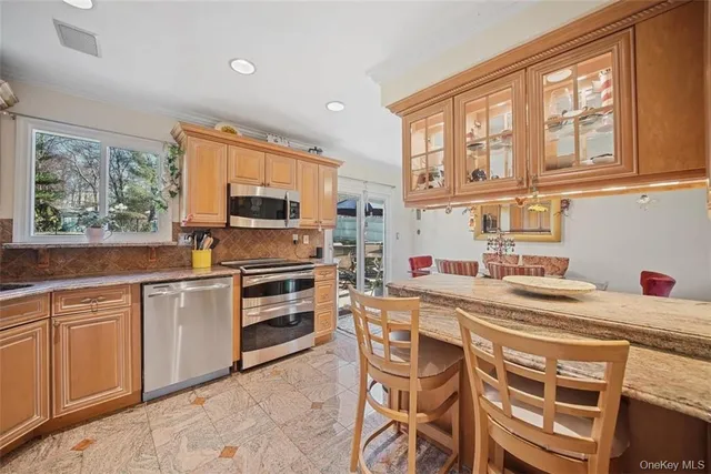 a kitchen with stainless steel appliances a stove a sink and cabinets