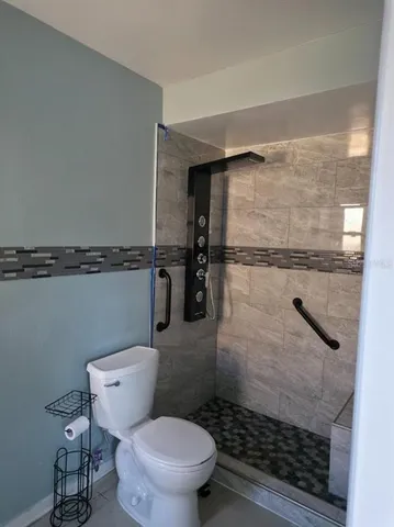 a bathroom with a toilet and a shower