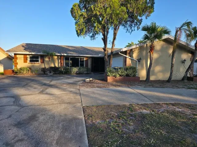 a front view of a house with a tree
