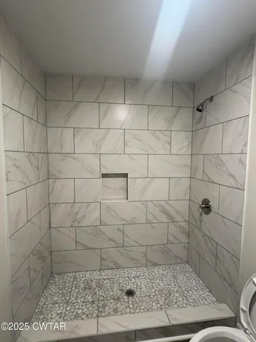 a bathroom with a granite countertop sink a toilet and shower