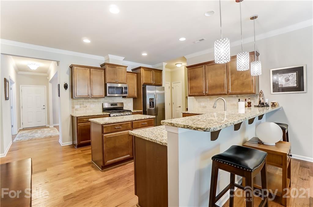 1765 Still River Way Fort Mill, SC 29708 - Photo 12 of 46 a kitchen with kitchen island granite countertop wooden cabinets and refrigerator