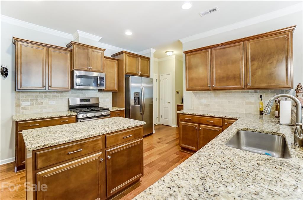 1765 Still River Way Fort Mill, SC 29708 - Photo 13 of 46 a kitchen with stainless steel appliances granite countertop a stove refrigerator sink and cabinets