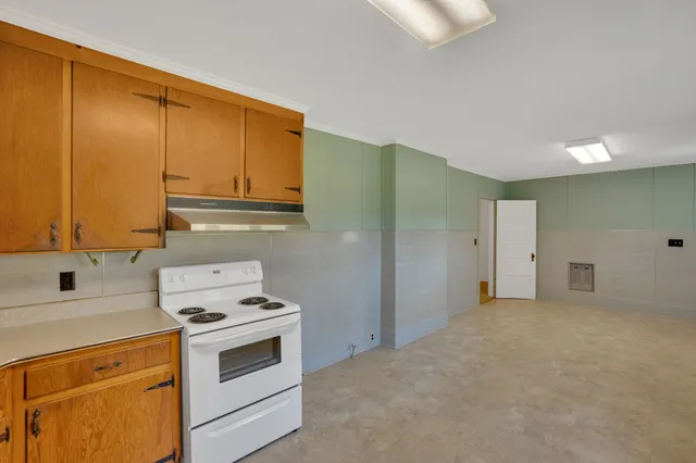 a large kitchen with stainless steel appliances granite countertop a stove a sink and a microwave
