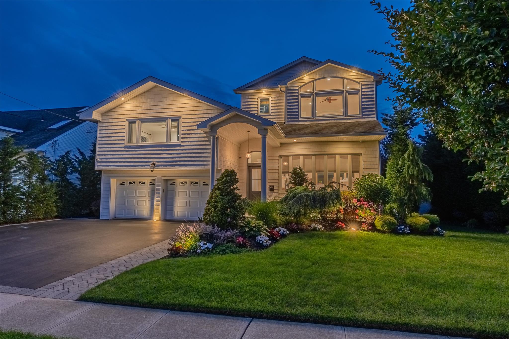 2904 Harbor Road Merrick, NY 11566 - Photo 1 of 1 Traditional-style home featuring an attached garage, a lawn, and driveway