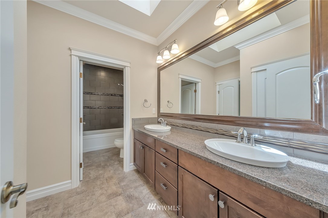 17725 Southeast 123rd Place Renton, WA 98059 - Photo 31 of 37 a spacious bathroom with a granite countertop sink a mirror and a bathtub