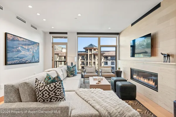 a living room with furniture large window and a fireplace
