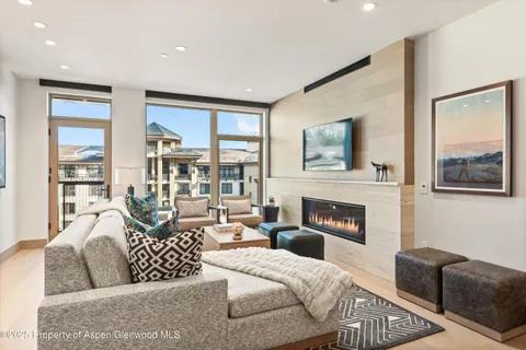 a living room with furniture large window and fireplace