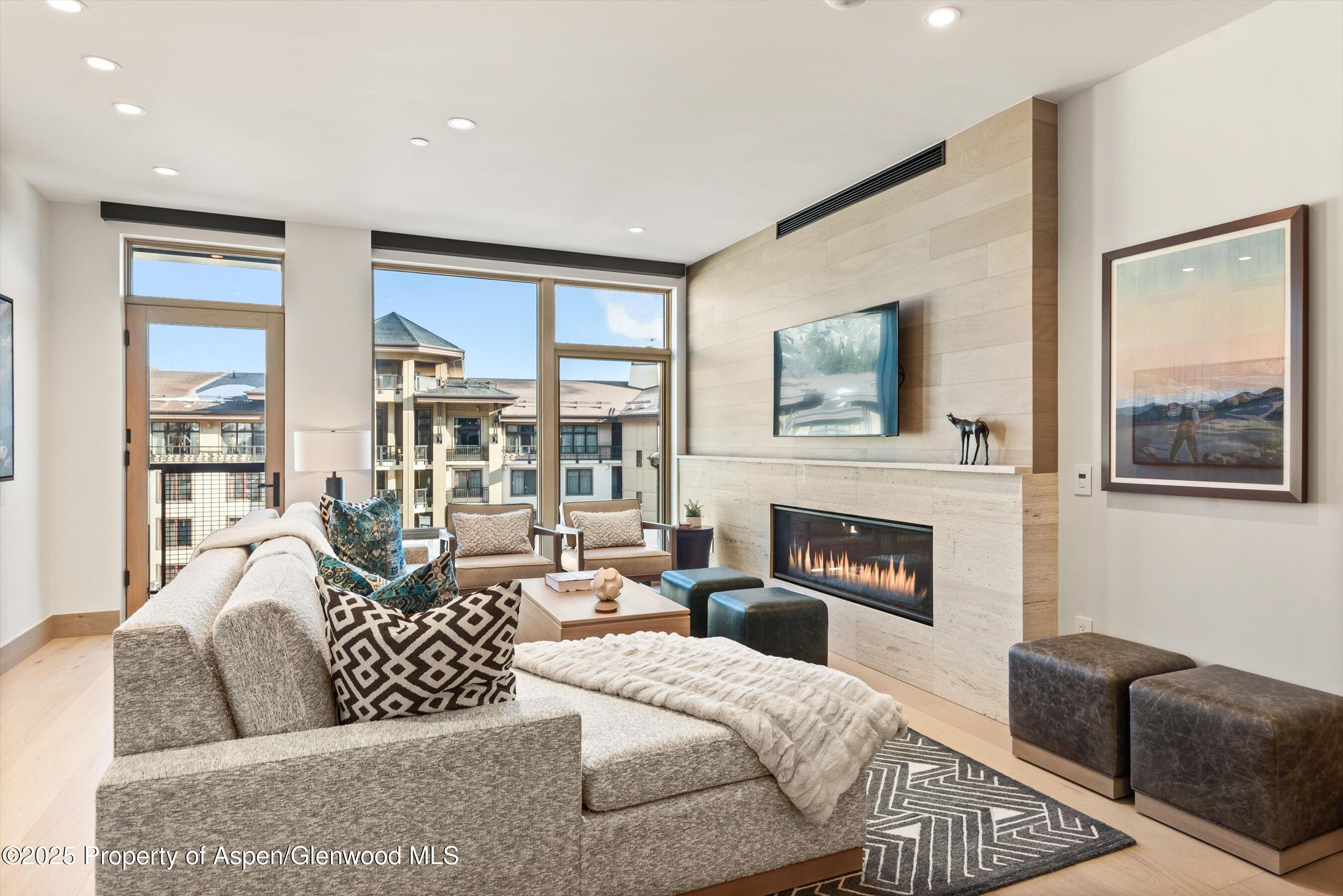 130 Wood Road, Unit 560562 Snowmass Village, CO 81615 - Photo 4 of 37 a living room with furniture large window and fireplace