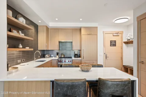 a kitchen with granite countertop a sink stove and refrigerator
