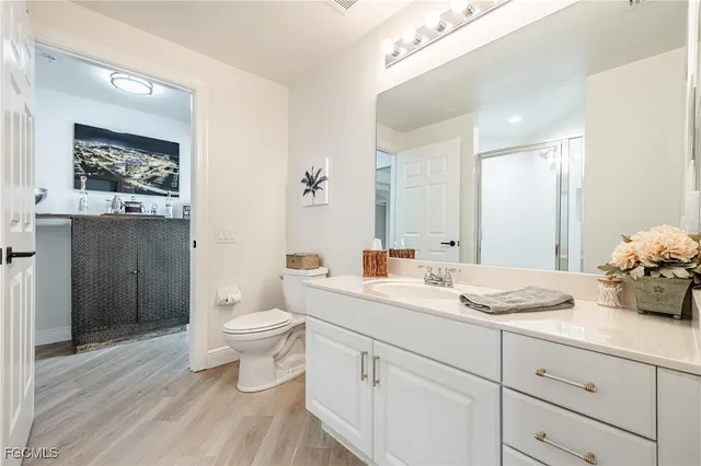 a bathroom with a granite countertop toilet sink and mirror