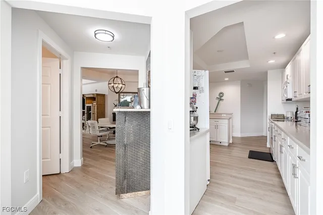 a view of a kitchen with refrigerator and wooden floor