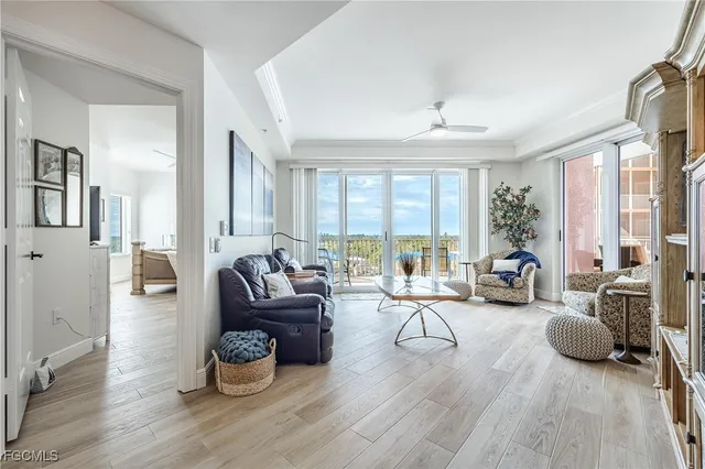 a living room with furniture large window and wooden floor