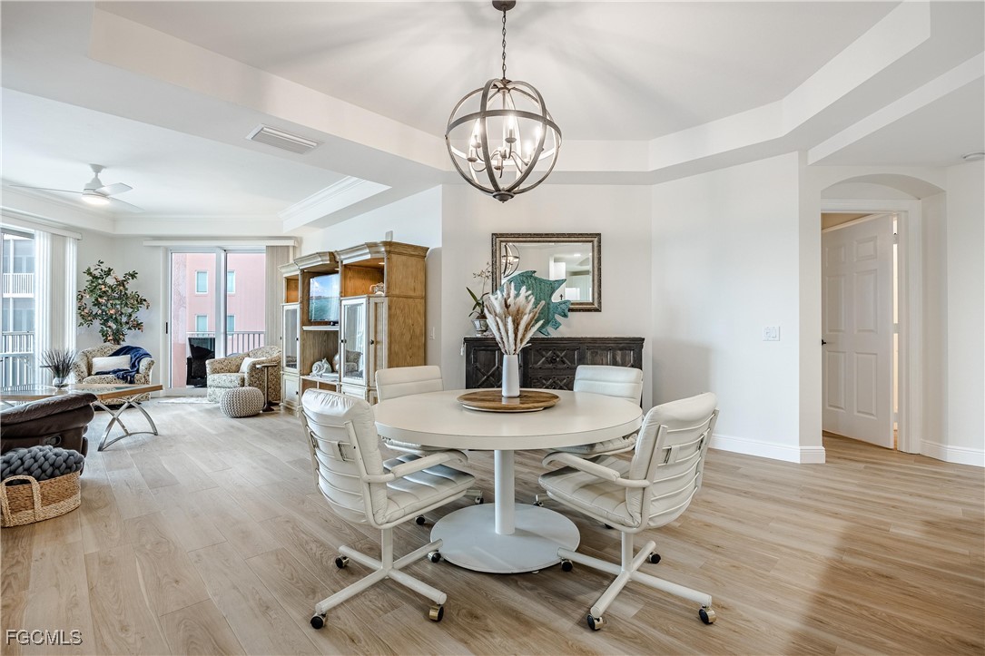 2745 First Street, Unit 705 Fort Myers, FL 33916 - Photo 21 of 49 a view of a dining room with furniture wooden floor and chandelier