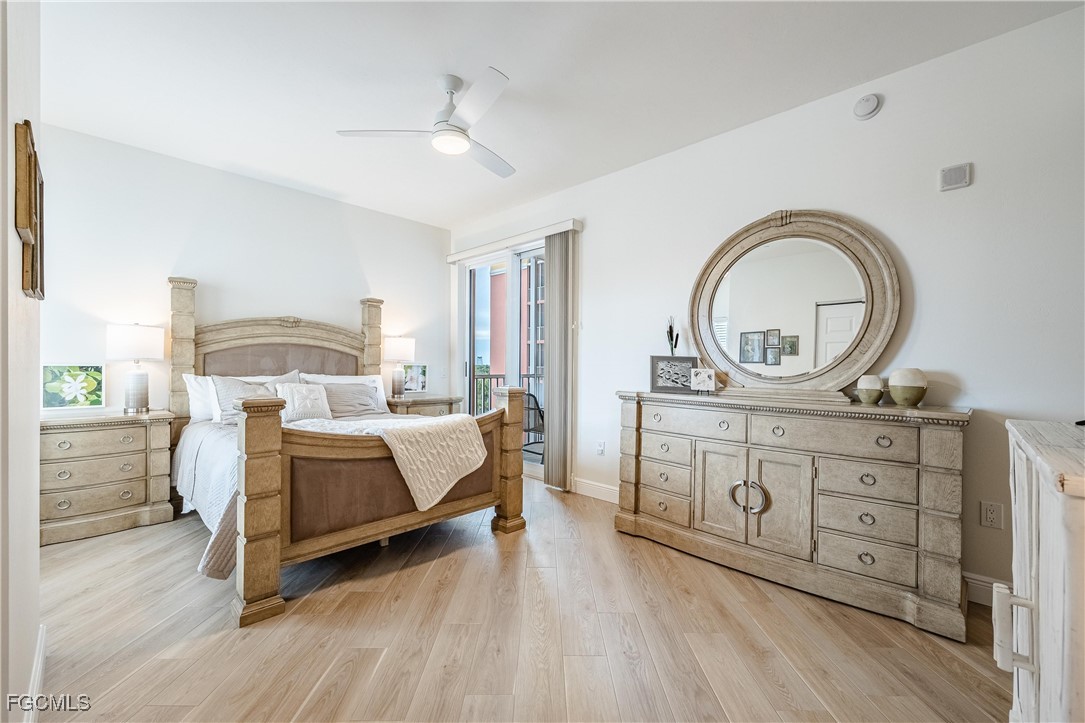 2745 First Street, Unit 705 Fort Myers, FL 33916 - Photo 8 of 49 a bedroom with a bed a mirror on dresser and a wooden floor