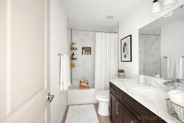 a bathroom with a granite countertop sink a toilet and shower